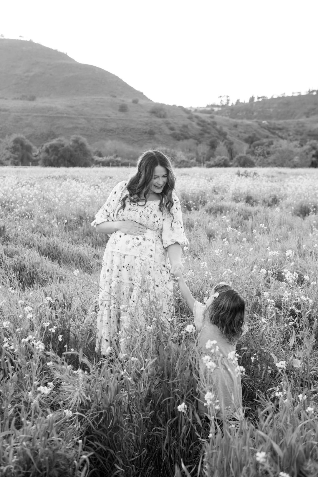 pregnant mother in a beautiful field with her daughter