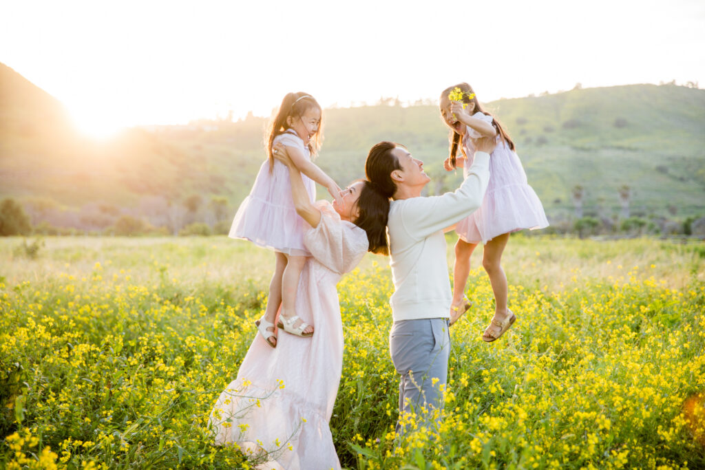 family playing in a beautiful yellow flower field