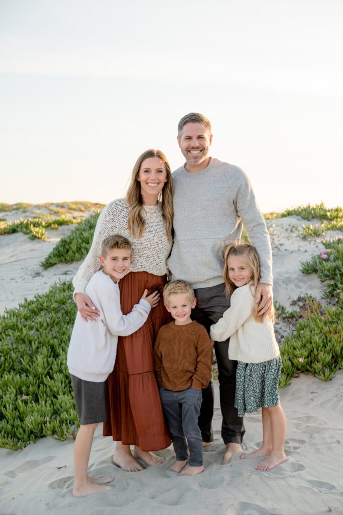 happy family of five smiling at the camera during their sunset photo session in san diego with photographer mattie taylor photography
