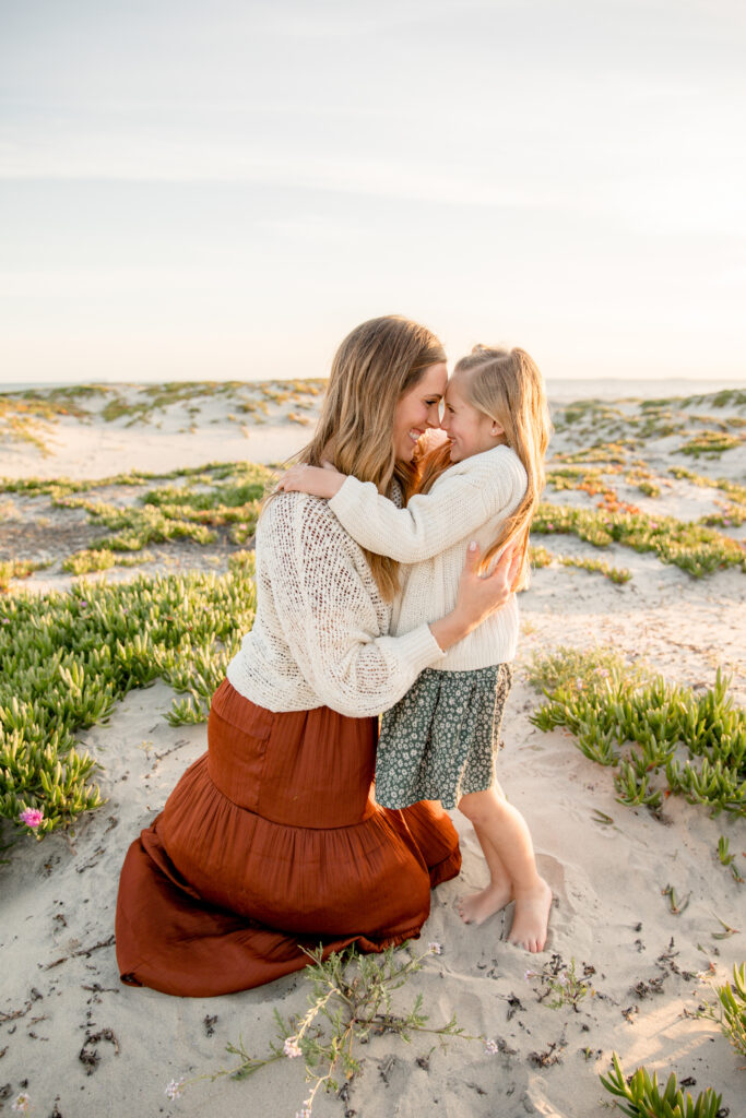 mother and daughter snuggling in during family photo session in san diego